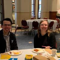 A man and a woman sitting at a table, smiling for a picture